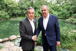 Chinese Foreign Minister Wang Yi shakes hands with Russian Foreign Minister Sergei Lavrov during a meeting on Sunday